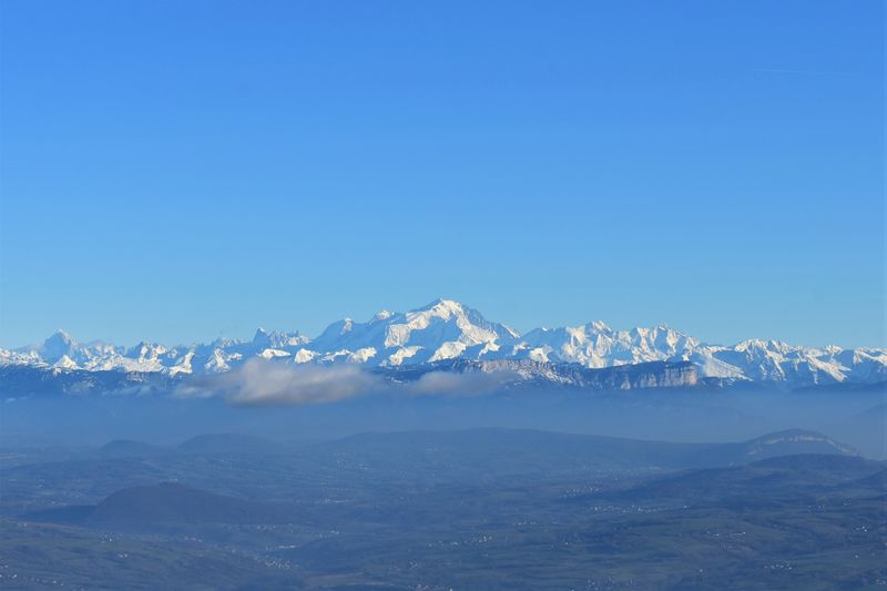 Snow-capped Mont Blanc massif rising above hazy blue valleys